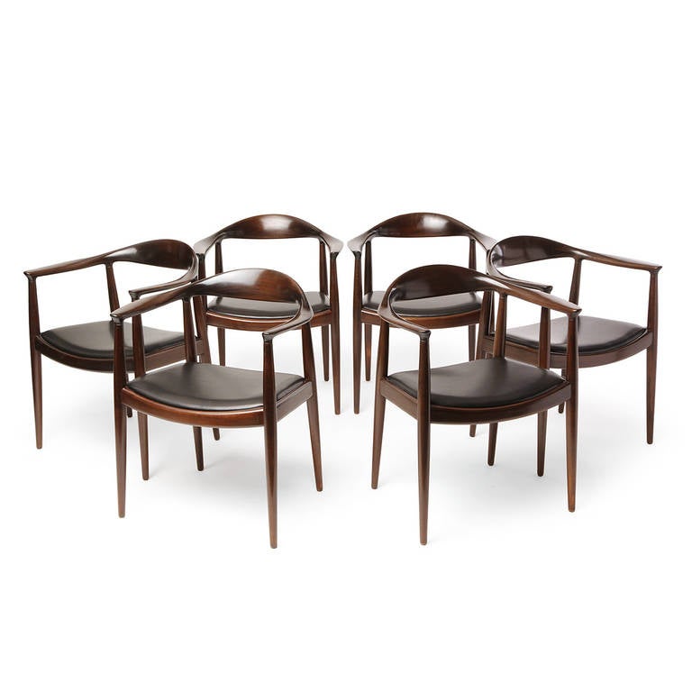 An excellent group of sculptural and elegant hand-crafted mahogany Round chairs having exposed frames and oiled leather seats.