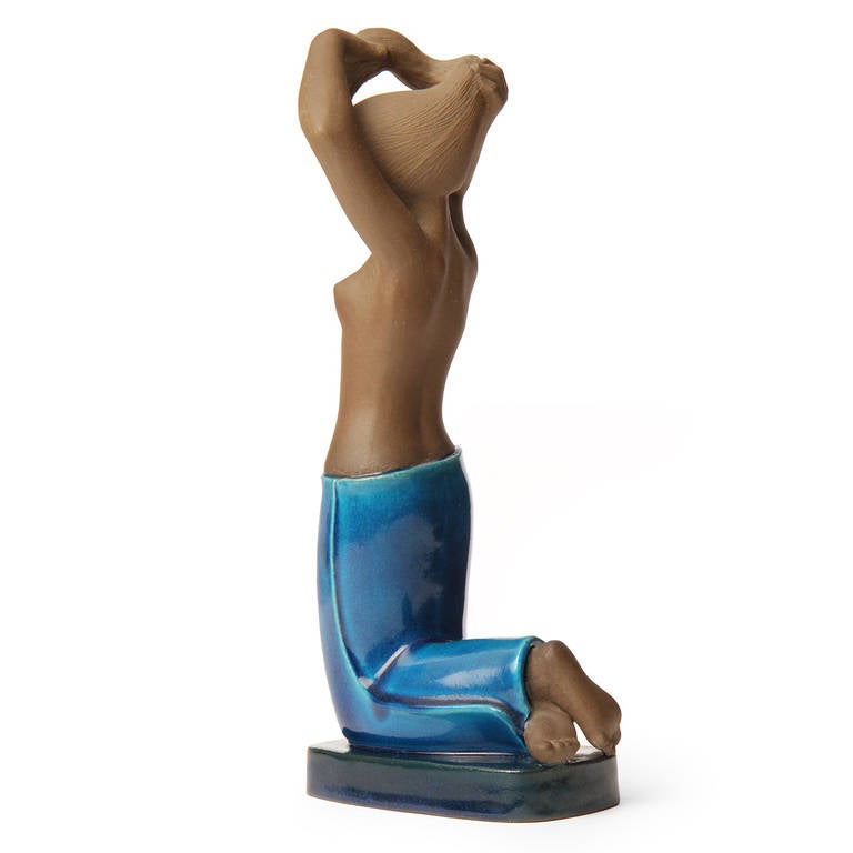A beautifully modeled and graceful ceramic sculpture of a woman, the body having an unexpected and striking combination of unglazed brown stoneware and a rich turquoise glaze.