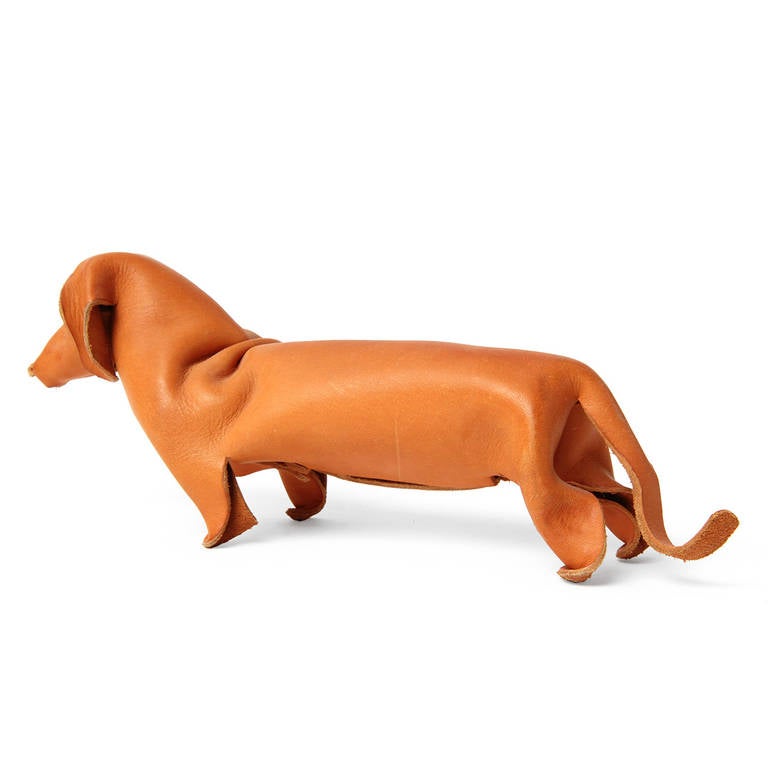 A delightful and expressive dachshund ingeniously formed from a single sheet of crimped, pinched, cut and riveted natural leather.