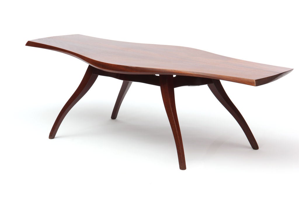 A bench made American Craftsman low / coffee table created by Ron Smith from solid mahogany featuring an undulating top and splayed, serpentine legs. Made in the USA, circa 1980s.