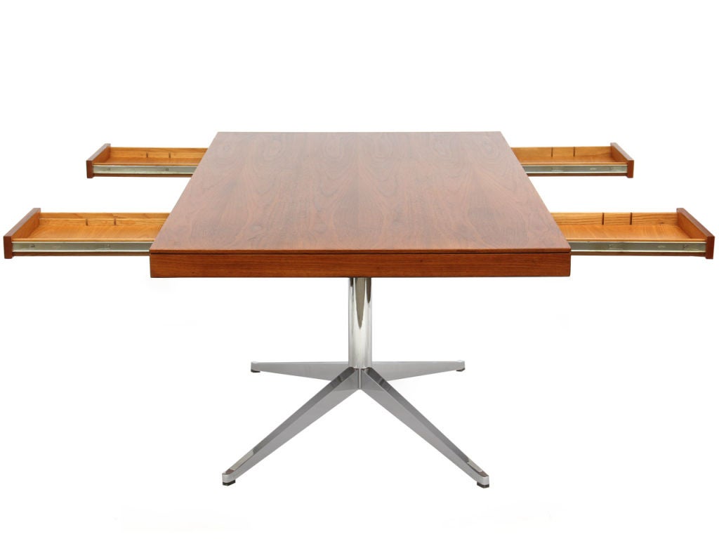 A teak partners desk with two slim drawers on each side atop a heavy machined chromed steel base. Design by Florence Knoll for Knoll Associates