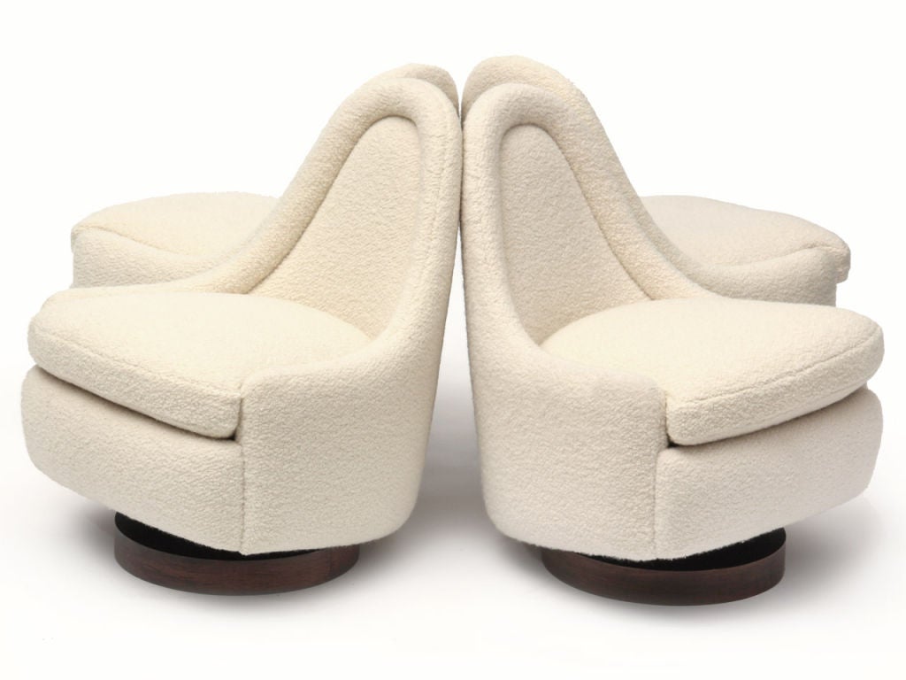A slipper chair in white wool boucle on a rosewood-veneered disc base with a tilt-and-swivel mechanism. Design by Milo Baughman for Thayer Coggin