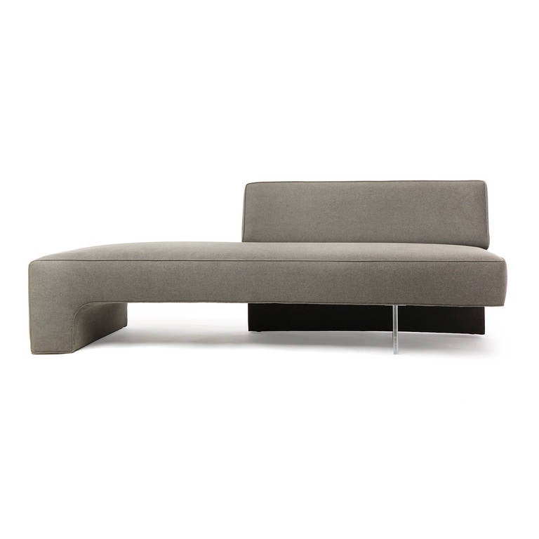 A geometric, uncommon and finely proportioned demi-backed sofa from the Omnibus collection having a waterfall edge and covered in a plush grey velvet upholstery