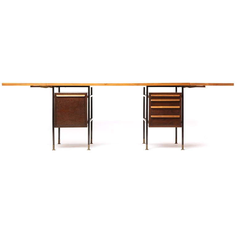 A fine, architectural and uncommon double drop-leaf desk, the figured walnut top hovering above two floating compartments suspended within a lacquered metal frame with expressive brass feet.