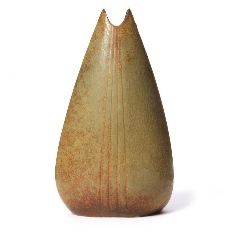 A finely rendered and beautifully proportioned ceramic vase having a teardrop form with subtle incised decoration and covered in a rich rust-to-bronze matte glaze.