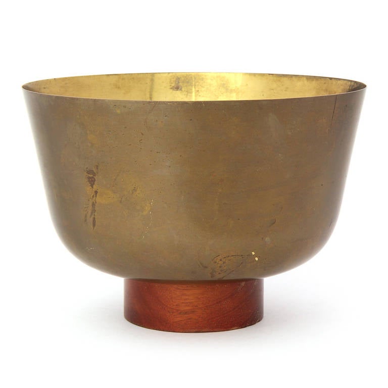 A finely rendered high-walled lacquered brass bowl that retains its original patina and rests on a turned walnut disc base.