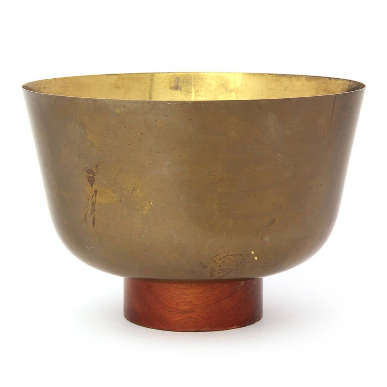 Eine fein gearbeitete, hochwandige, lackierte Messingschale, die ihre ursprüngliche Patina bewahrt hat und auf einem gedrechselten Nussbaumsockel ruht.