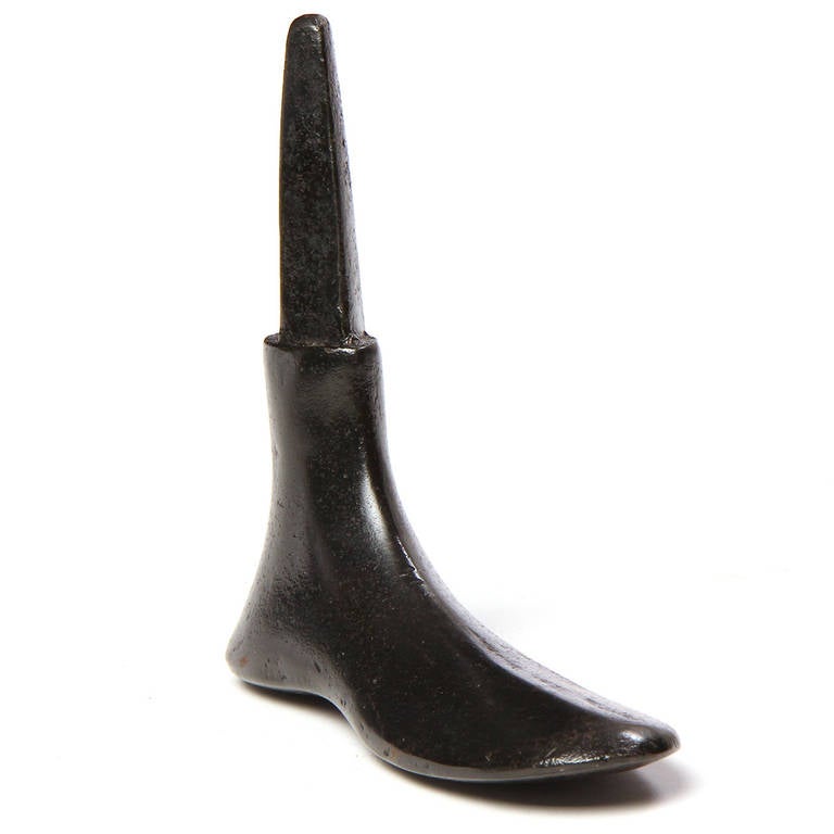 Une forme de cordonnier en fonte finement rendue, avec une riche patine noire.