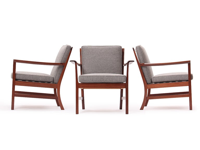 A generously proportioned Scandinavian Modern lounge chair designed by Ole Wanscher for A.J. Iversen. This chair features an architectural exposed Cuban mahogany frame with shaped and discretely curved arms. Seat and Back cushions upholstered in