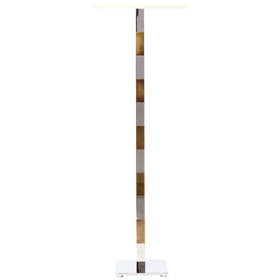 An elegant Mid-Century Modern floor lamp designed by Stewart Ross James featuring alternating sections of brass and chrome rising from a square chrome footed base. Made in the USA by Hansen, circa 1970s.