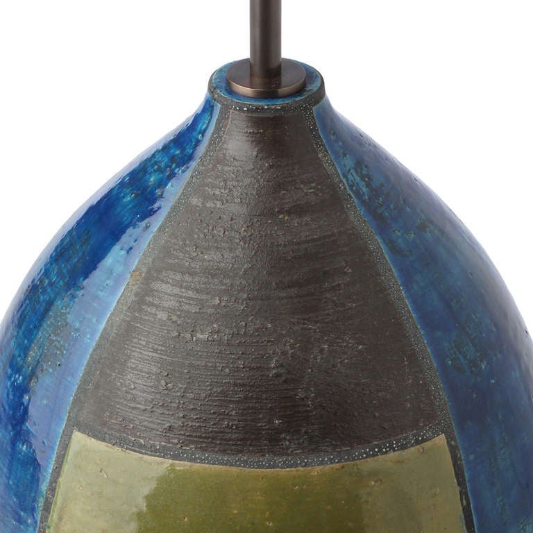 A graphic, well-scaled and expressive  hand-thrown table lamp having delineated segments richly glazed in olive, cerulean and mocha hues.