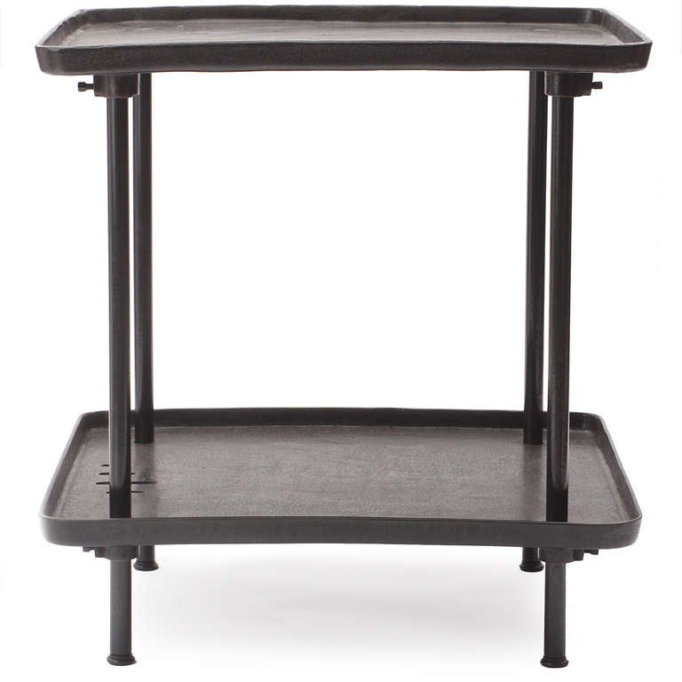 A tall, heavy and well-crafted square two-tiered industrial table rendered in richly patinated steel and iron, with each shelf having raised edges.
