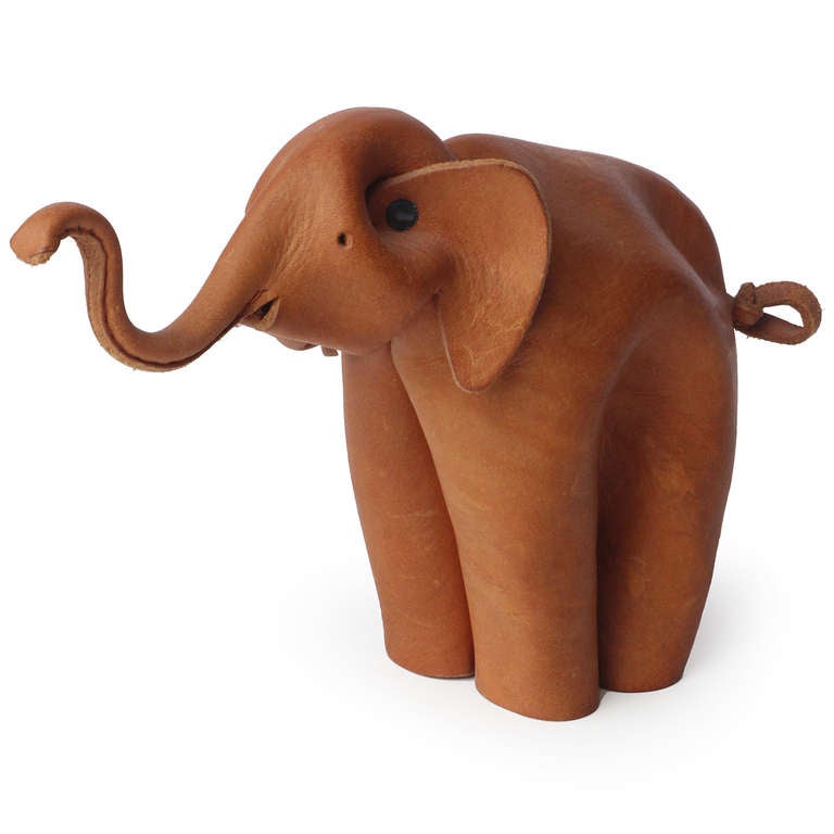 An elephant with an upturned trunk formed from a single sheet of crimped, pinched, cut and riveted leather.