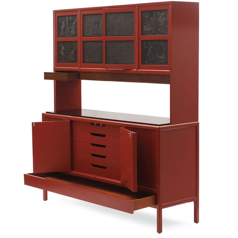 A two-level cabinet having fantastic storage and scale, with a rich custom cinnabar lacquer. The lower level has bi-folding doors concealing a bank of drawers; the upper section features doors with inset antique Chinese printing blocks.