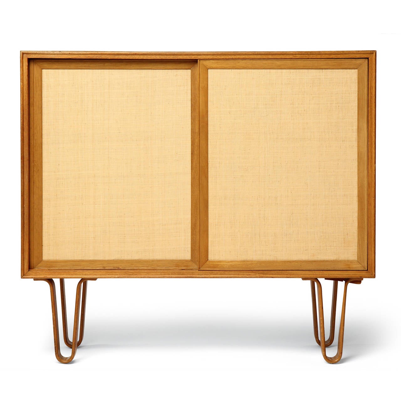 A spare and elegant rectilinear cabinet with grass cloth-fronted sliding panels concealing adjustable shelves, the case floating on sculptural hairpin turn bentwood legs.