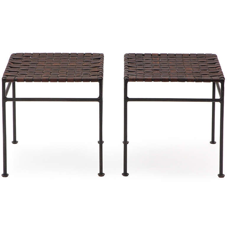 A warm and elegant pair of hand-made stools in wrought iron retaining their original thick butterscotch woven leather webbing.