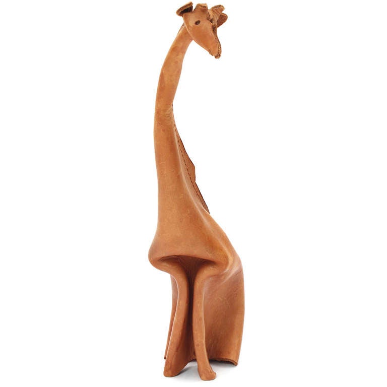 A whimsical and expressive tall giraffe ingeniously formed from a single sheet of folded, pinched and cut natural leather.