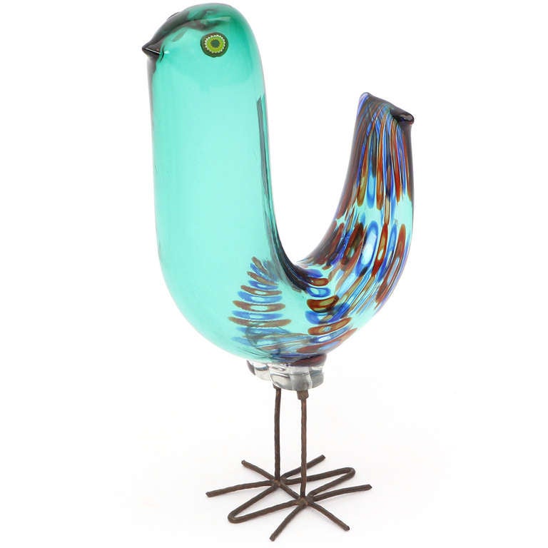 A rare and beautiful hand blown glass bird, perched upon hand cut brass legs.