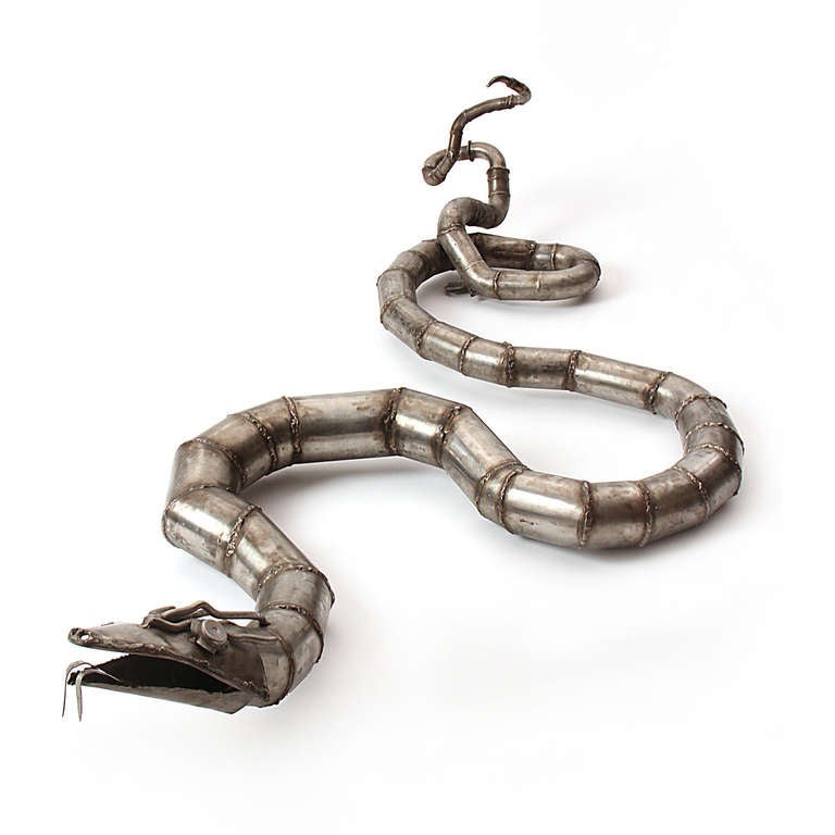 Una scultura a parete di un grande serpente realizzato con tubi d'acciaio saldati e altre parti in acciaio.