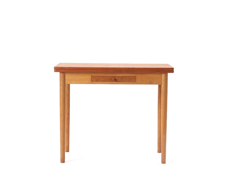 A small solid teak flip-top table with tapered legs. Crafted by Andreas Tuck. Can be used as a desk, writing table, side table, or dining table.

Closed: 33.75