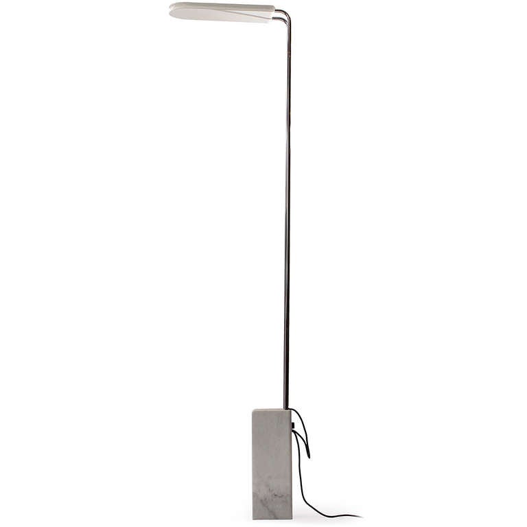 A tall, graceful and sculptural halogen floor lamp having a carved marble base (with a recessed handle) supporting parallel steel uprights and a white enameled hood.