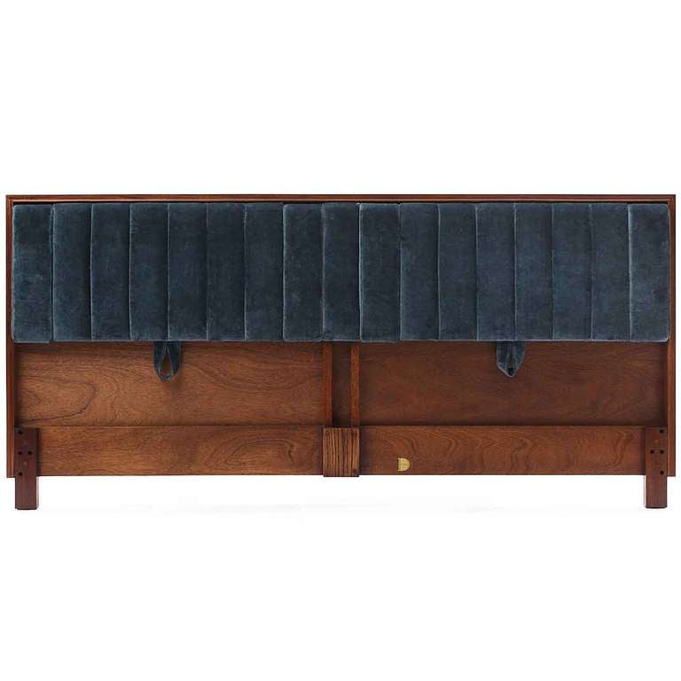 An innovative and elegant headboard in walnut having channeled blue velvet upholstery, adjustable back rests and two pairs of drop-down arms. Designed by Edward Wormley for Dunbar.