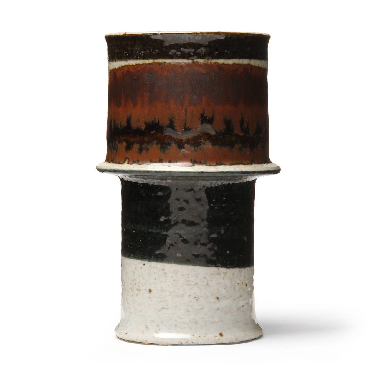An impeccable and unique studio stoneware footed vase having a cylindrical and sculptural form decorated with expressive earth toned glazed bands of color.
