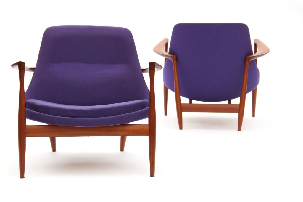 A pair of Elizabeth lounge chairs with exposed teak frames and purple upholstery. Designed by Ib Kofod-Larsen