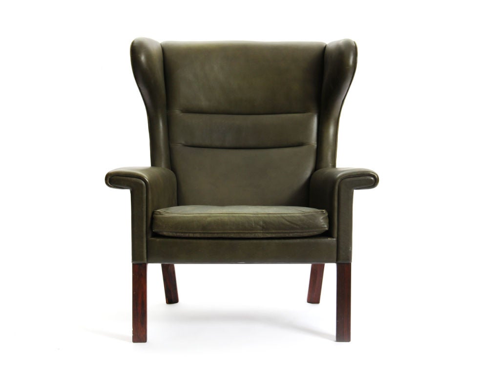 A rare lounge chair with rosewood legs in the original olive-green leather, excellent patina and matching rosewood framed ottoman. By Hans Wegner for A.P. Stolen. 23