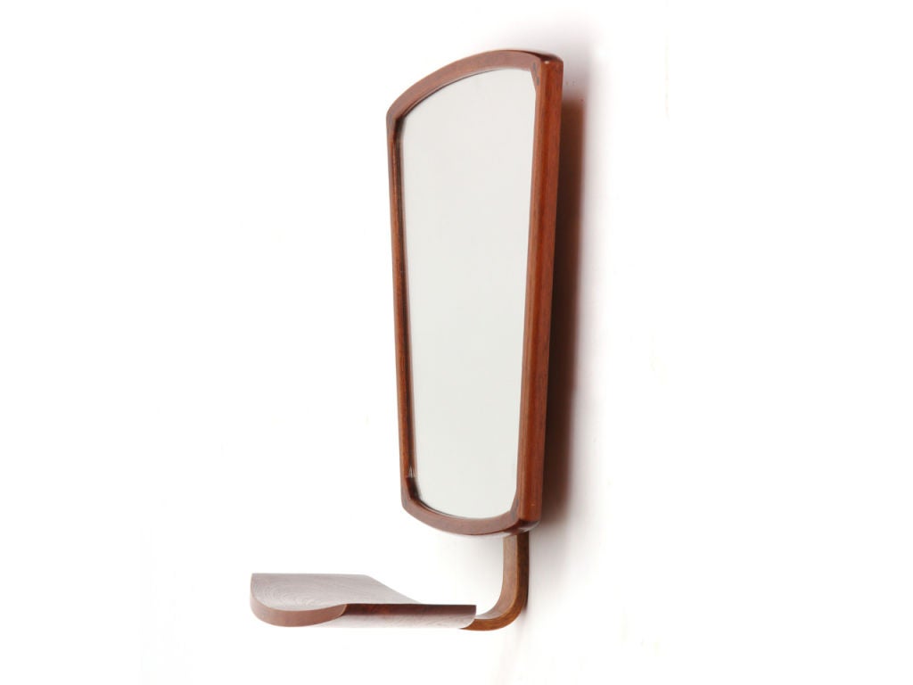 A unique teak wall mounted tilting vanity/dressing mirror with a bowed shelf.