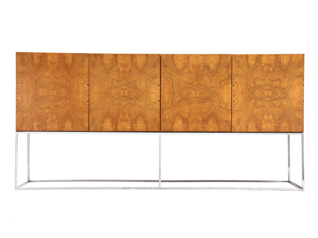 A four (4) door burled credenza supported by a simple square chromed steel frame. Design by Milo Baughman made by Thayer Coggin