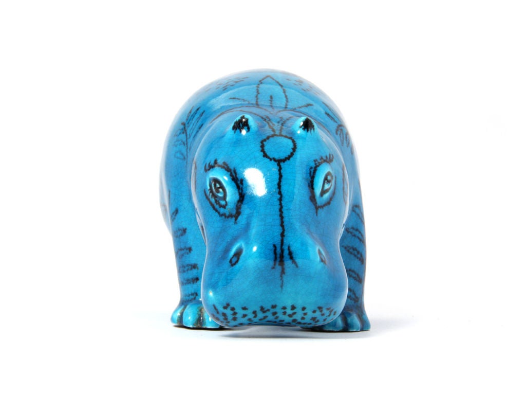 A ceramic hippo with turquoise blue glaze and floral / tribal pattern.