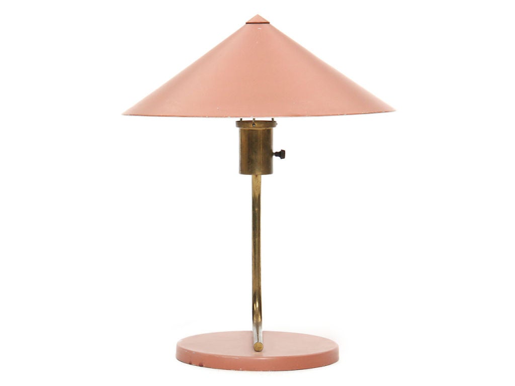 A desk lamp with a simple brass stem attaching an enameled metal shade and base.