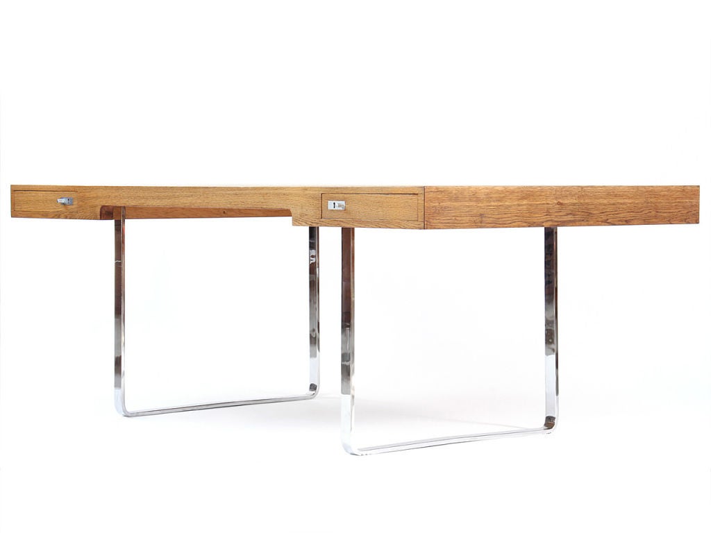Wegner designed this desk in 1970 as part of an office series which was produced in limited quantities. The oak work surface contains symmetrical locking drawers and rests on continuous polished chromed steel legs.<br />
<br />
Matching office