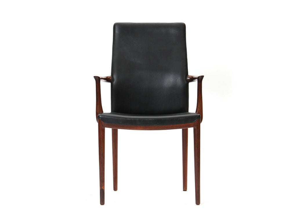 A rosewood framed high-back armchair with original black leather upholstery.