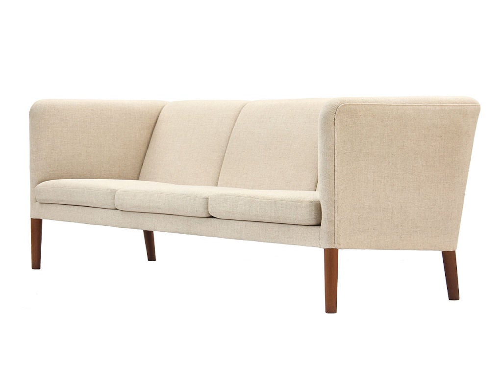 A high-arm three seat sofa with oak legs in the original wool upholstery.