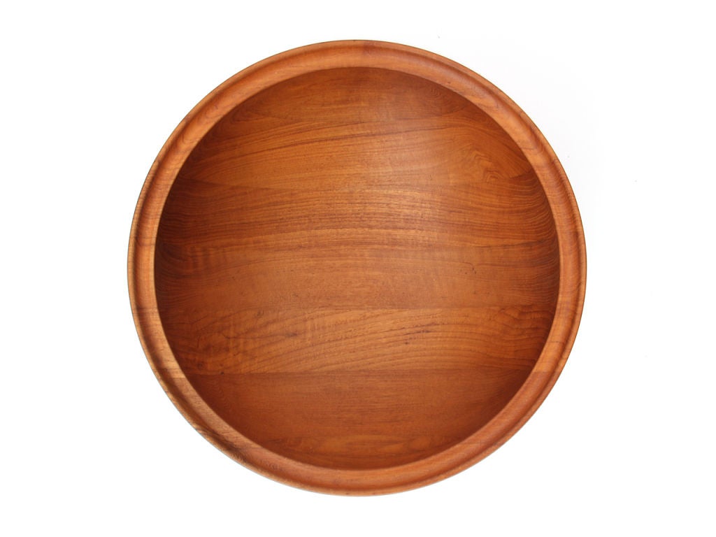 A large turned teak serving bowl with rimmed edge.