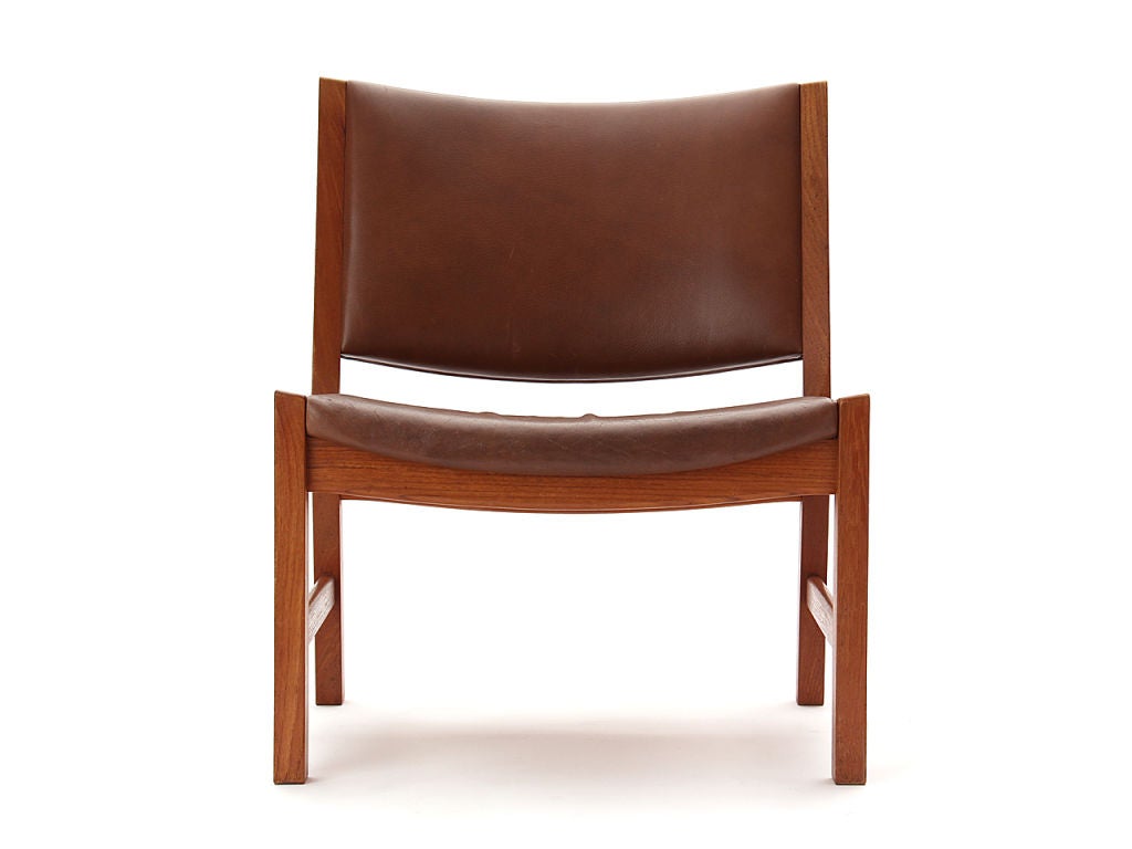 A rare pair of low teak armless lounge chairs retaining the original brown oxhide leather upholstery. Marked with Johannes Hansen tags, but originally produced by AP Stolen.