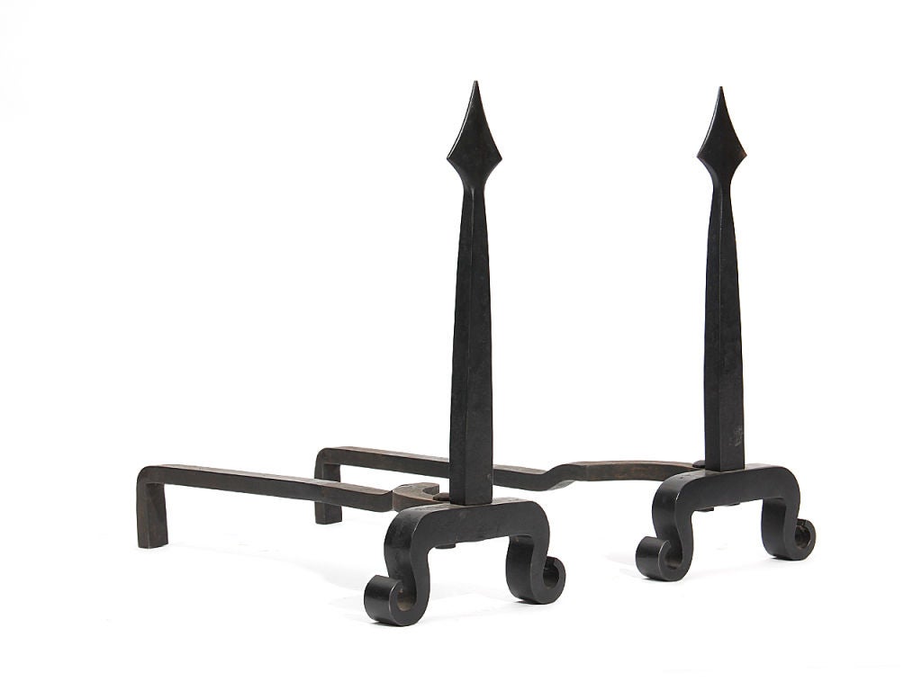 A pair of wrought iron andirons with a spear head finial.