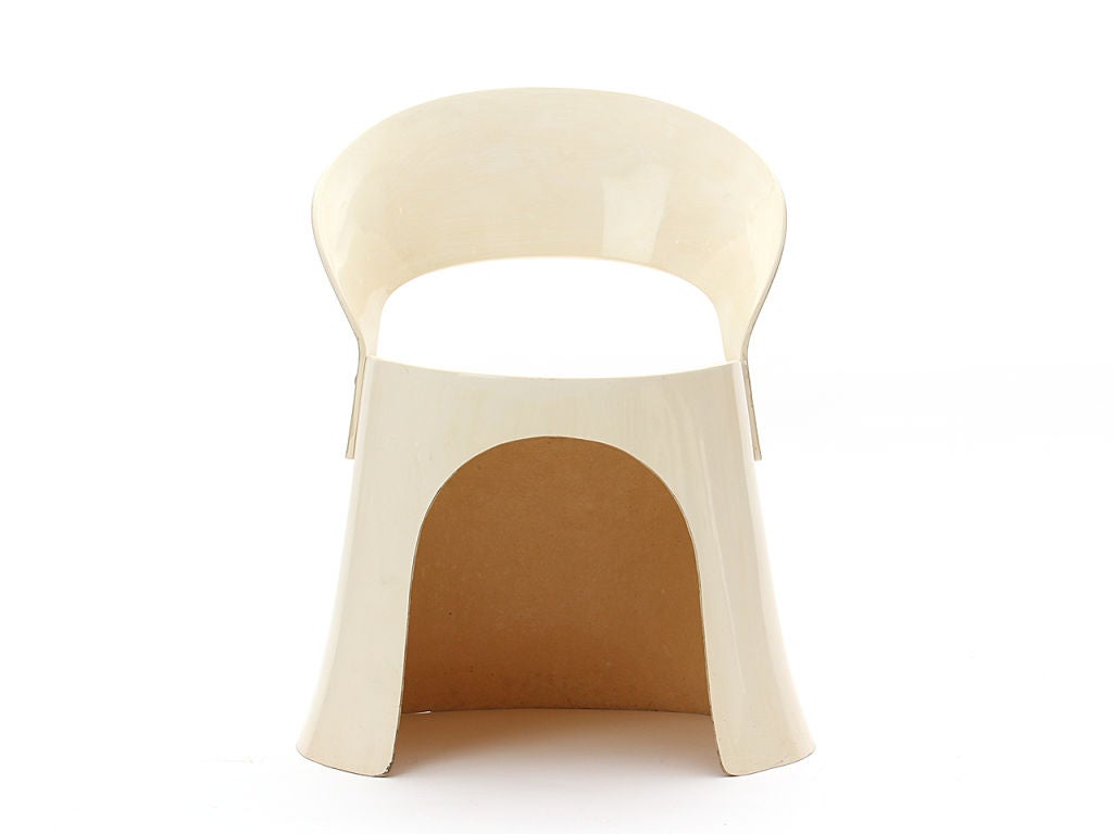 A set of four off-white fiberglass dining chairs.