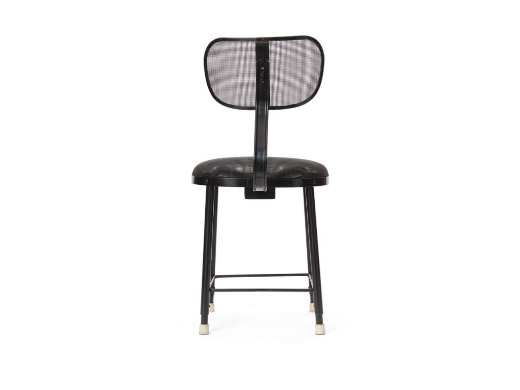 A fully adjustable draftsman stool or desk chair with patinated wire mesh seat and back, over tubular steel legs.