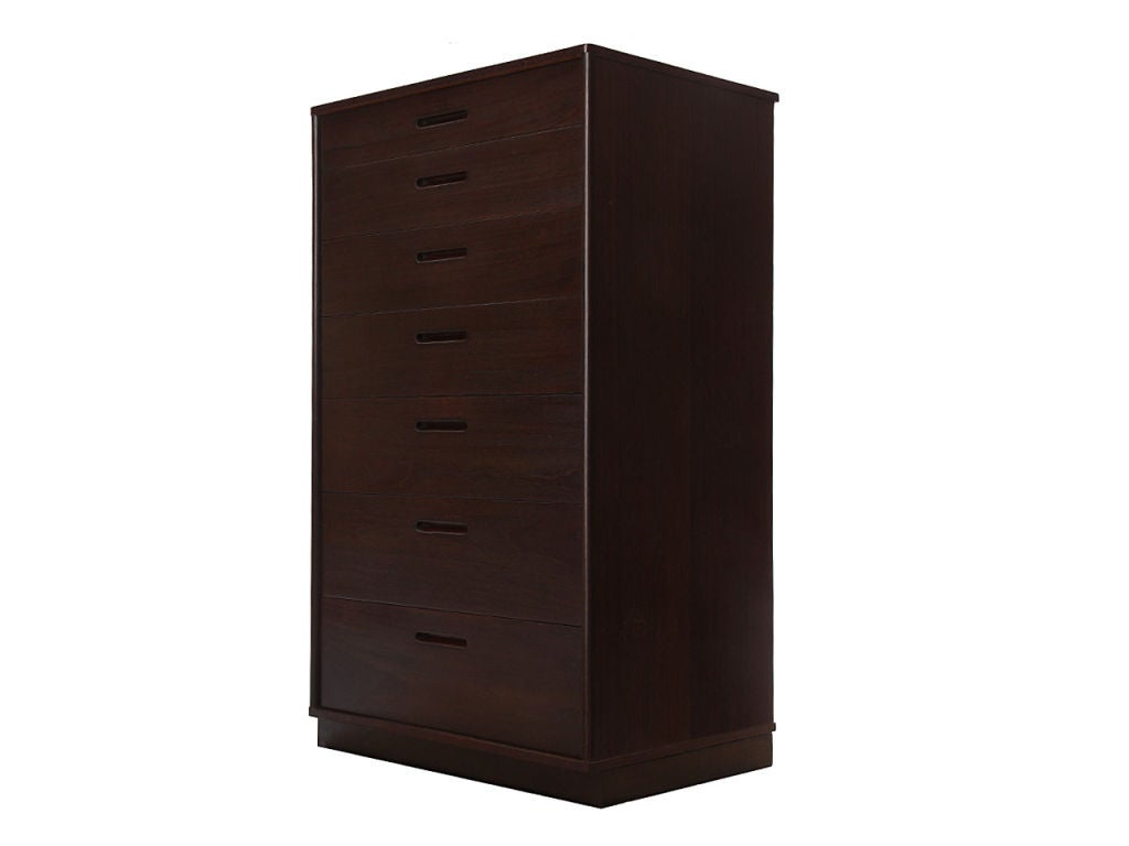 An ebonized mahogany cabinet with seven graduated, recessed-pull drawers, on a recessed plinth leather wrapped base.