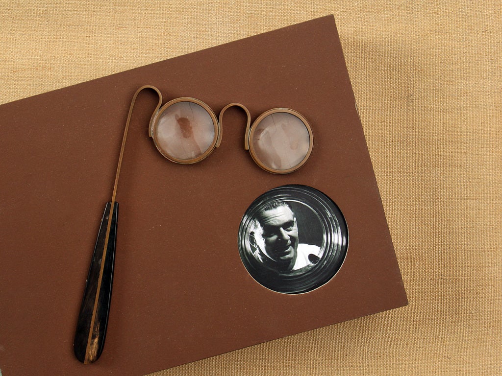 A pair of magnifying glasses with a brass and bone handle.