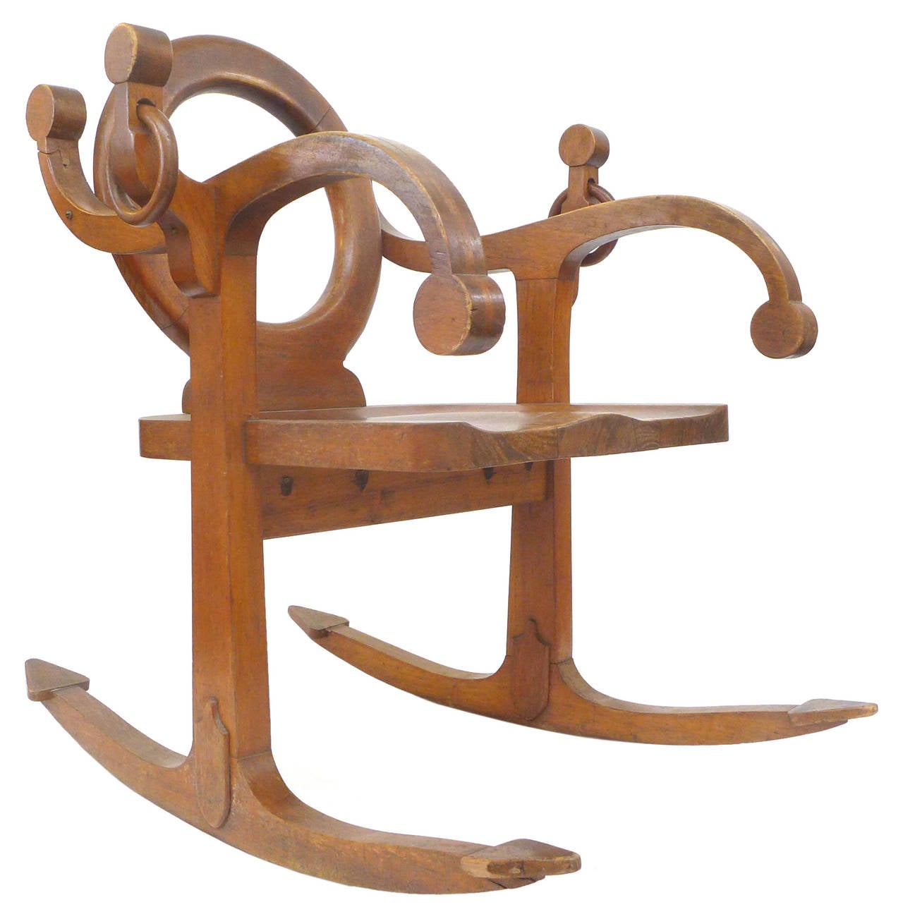 A wonderfully unusual rocking chair playfully utilizing the form of a ship's anchor. Elegant and surreal with figural, nautical elements throughout, including anchor-arms and flukes for rocking rails, hanging ring handles, alternately twisting stock