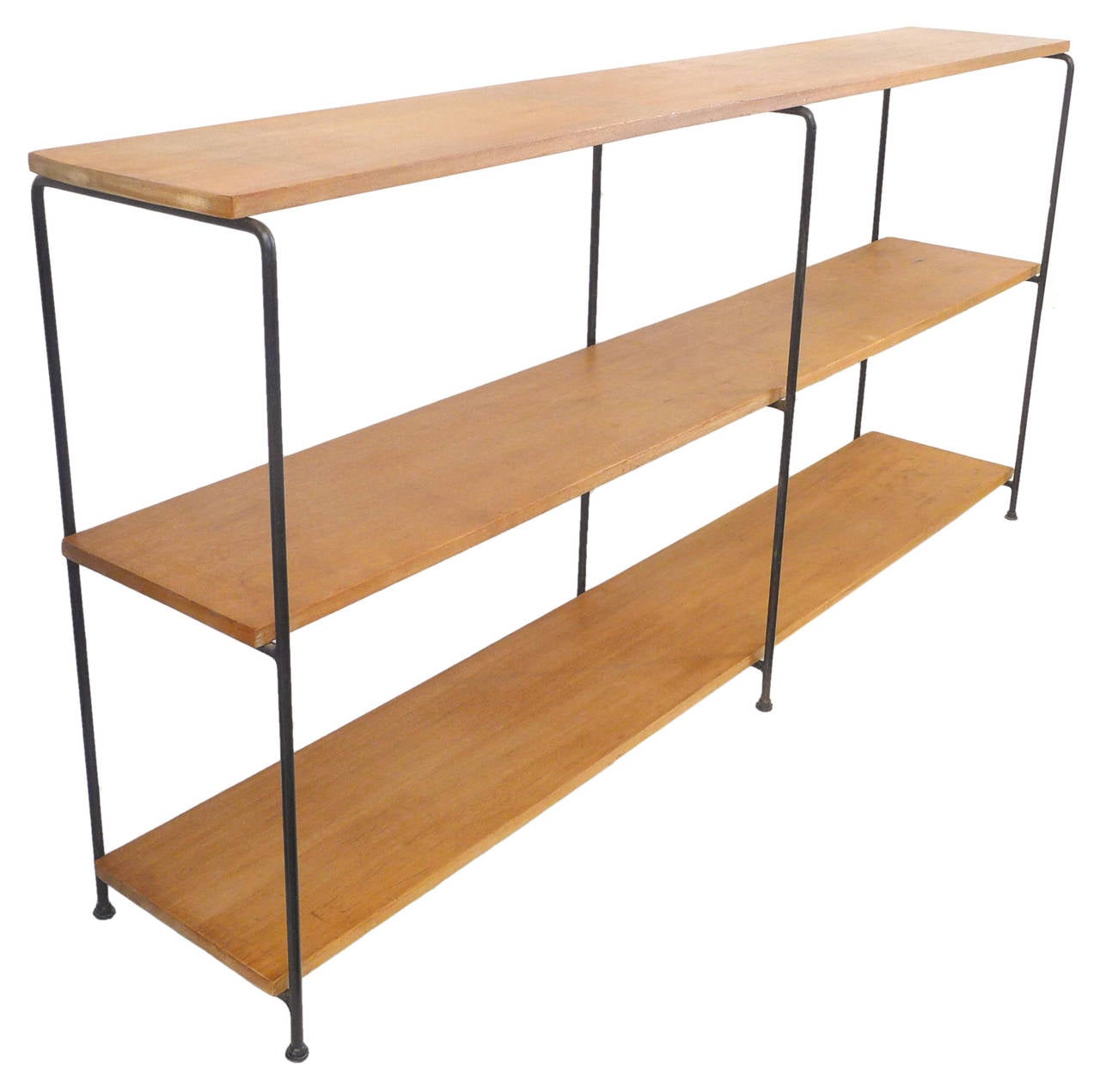 A Classic, Mid-Century shelving unit of wrought iron and solid mahogany planks. Highly reminiscent of the work of Muriel Coleman, a statement of beautiful simplicity and architectural design. Piece rests of its original, glider-pod feet and wears a