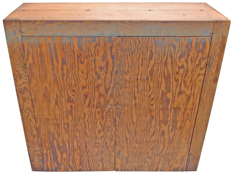 An incredible primitive cabinet in Douglas Fir plywood.  With a surface wearing a fantastic patina of extraordinary uniformity, exposed corrugated fasteners and hook & eyelet latch, this piece is a prime example of 1940s American utilitarian