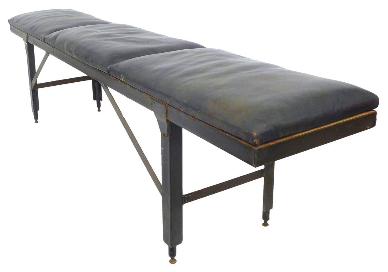 A handsome, scratch-built bench of cut and welded steel with leather upholstery.  A substantial, supremely sturdily-built, primitive piece with a great, rectilinear profile and much desired patina from years of use.  Adjustable-height bolt feet.  A
