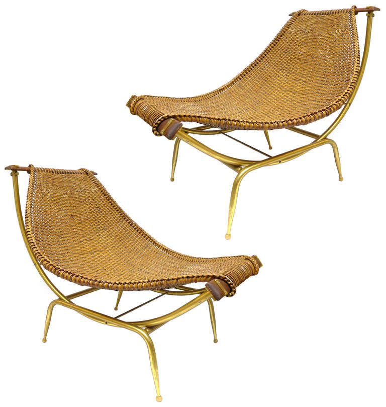 A wonderful, matched pair of woven rattan, aluminum and wood lounge chairs designed by John Risley. Fully adjustable, as their woven slings nest and move as desired into the leg structure cradle. An interesting gold anodized aluminum frame variation
