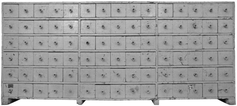 A monumental and graphically stunning 90 drawer apothecary cabinet with a beautifully distressed battleship grey painted surface. This wonderful piece came from the Stevens Linen Company in Massachusetts and dates back to 1842 when that company was