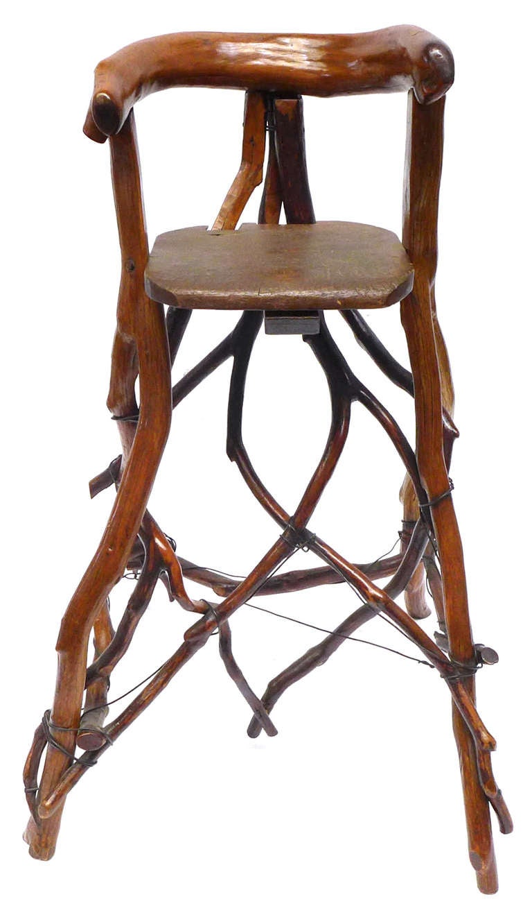 An unusual and beautiful high chair of twig-construction with a wire support structure laced throughout.  A rough-yet-elegant, wonderfully sculptural example of 1940s Adirondack Americana.  A fantastic mix of organic simplicity and artful
